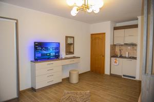 a living room with a flat screen tv on a dresser at SUNLIGHT in Ulcinj