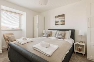 1 dormitorio con 1 cama grande y toallas. en Modern 1 Bed, close to beach and highstreet, en Southbourne