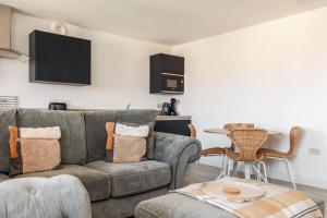 a living room with a couch and a table at Modern 1 Bed, close to beach and highstreet in Southbourne