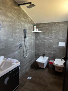 een badkamer met een douche, een wastafel en een toilet bij Posh villa 1 in Kavajë