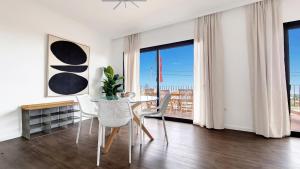 a dining room with a table and chairs and a balcony at Costa Vista by LovelyStay in Funchal