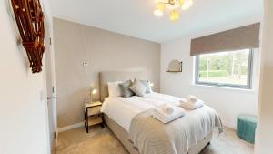 a bedroom with a bed with towels on it at 31 Caledonia Place in Aviemore