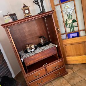 a wooden cabinet with a tea kettle in it next to a door at Peaceful@Swansea In Rosebank-Parkwood in Johannesburg