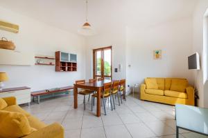 a living room with a table and a yellow couch at Villa Alba fronte mare in Carovigno +28 photos