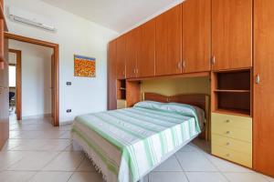 カロヴィーニョにあるVilla Alba fronte mareのベッドルーム(ベッド1台、木製キャビネット付)