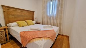 1 dormitorio con 1 cama blanca grande con almohadas amarillas en Àtic Trobador, en Barcelona