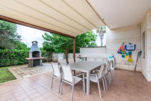 a patio with a table and chairs and a grill at Villa Alba fronte mare in Carovigno