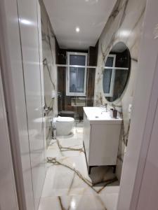 a bathroom with a sink and a toilet and a mirror at JD villa in Vlorë +31 photos