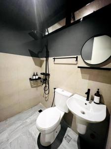 a bathroom with a white toilet and a sink at Couple Room near Clark (Casa Isabela) in Mabalacat