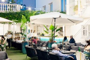 eine Gruppe von Menschen sitzt in einem Restaurant im Freien in der Unterkunft Villa Zaccardi in Rom