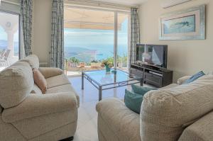 a living room with two couches and a television at La Nuestra CaRo in Salobreña