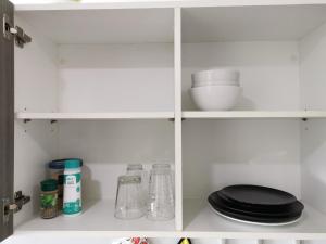 a white cabinet with black plates and dishes on it at 7 Floor - Ozone Condotel near Kata beach by 15 minutes walking in Kata Beach