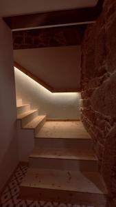 Una escalera en una habitación con una pared de ladrillo en CASA MEIGO, en Chantada