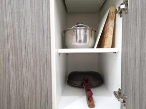 a cabinet with a pot and a knife in it at 7 Floor - Ozone Condotel near Kata beach by 15 minutes walking in Kata Beach