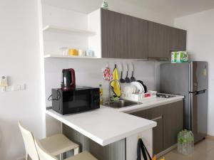 a small kitchen with a microwave and a refrigerator at 7 Floor - Ozone Condotel near Kata beach by 15 minutes walking in Kata Beach