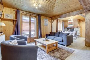 a living room with a couch and chairs and a table at Chalet Arthur in Morzine