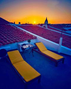 twee stoelen en een tafel met een zonsondergang op de achtergrond bij Casa Solua in Reguengos de Monsaraz