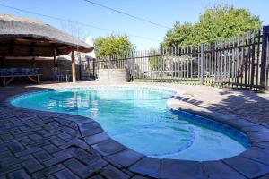 a small pool in a yard with a fence at AVONDBLIJ Apartment in Oudtshoorn