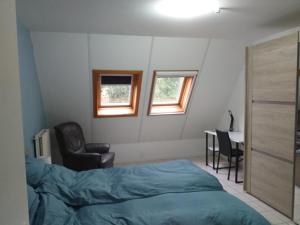 1 dormitorio con cama, silla y escritorio en logies 'Raapbreuk', en Herentals