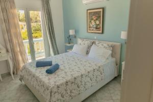 a bedroom with a bed with a blue pillow on it at Villa Alexandros in Ermioni