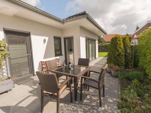 a patio with a table and chairs and a house at Ferienhaus Barbara, FeWo Vermittlung Nordsee in Varel