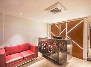 a red couch in a room with a lobby at De Mandarin in Bangalore