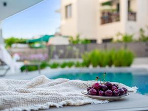 a plate of fruit on a table near a pool at Sanders Olive in Paphos City