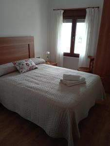 Un dormitorio con una cama con una toalla. en Casa rural La Barriada de Lago de Carucedo, en Lago de Carucedo