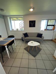 - un salon avec un canapé et une table dans l'établissement Apartment - Fíflholt, à Hvolsvöllur