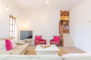 サン・リョレンツ・デス・カルダサルにあるFinca Can Setriのリビングルーム(ソファ、ピンクの椅子付)
