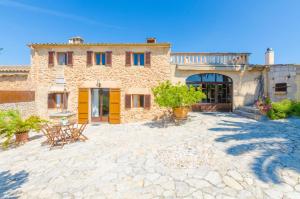 a stone building with chairs and tables in a courtyard at Finca Can Setri in Sant Llorenç des Cardassar