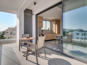 a room with a table and chairs on a balcony at Sanders Olive in Paphos City