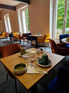 a table with plates and utensils on it in a restaurant at La Souveraine in Contrexéville