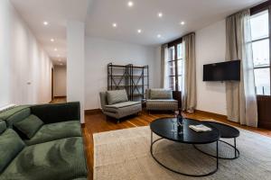 uma sala de estar com um sofá verde e uma mesa em SOUL suite apartment, PARKING INCLUDED em San Sebastián
