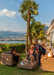 un grupo de personas sentadas alrededor de una mesa en Suitenhotel Parco Paradiso en Lugano