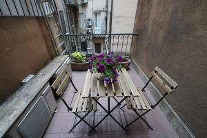 a table and chairs on a balcony with flowers at Holiday House Naiadis in Rome