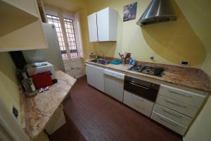 a kitchen with white cabinets and a counter top at Holiday House Naiadis in Rome