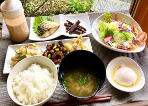 a table with plates of food and a bowl of rice at Assi in Yufuin