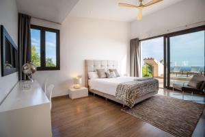 a white bedroom with a bed and a large window at Villa bonita con vistas espectaculares, perfecto para familias in Palma de Mallorca