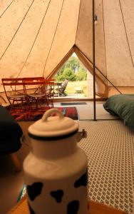 a tent with a table and chairs in a room at domaine des butineuses in Marchainville