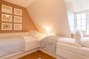 two beds in a attic bedroom with a window at Gelys Huus in Midlum