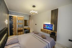 a bedroom with a bed and a flat screen tv at SUNLIGHT in Ulcinj