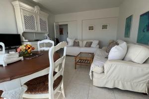 ein Wohnzimmer mit 2 weißen Sofas und einem Tisch in der Unterkunft Apartamento con acceso directo a la playa in Valencia