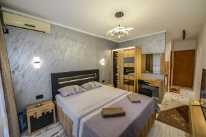 1 dormitorio con 1 cama grande y espejo en SUNLIGHT en Ulcinj