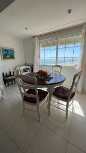 ein Esszimmer mit einem Tisch, Stühlen und einem Fenster in der Unterkunft Apartamento con acceso directo a la playa in Valencia