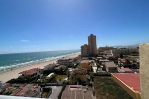 Blick auf einen Strand mit Gebäuden und das Meer in der Unterkunft Apartamento con acceso directo a la playa in Valencia