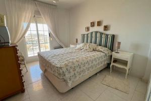 Schlafzimmer mit einem Bett, einem Tisch und einem Fenster in der Unterkunft Apartamento con acceso directo a la playa in Valencia