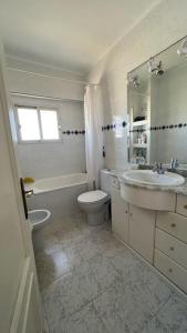 a white bathroom with a sink and a toilet at Apartamento con acceso directo a la playa in Valencia