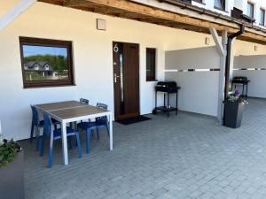 eine Terrasse mit einem Tisch, Stühlen und einem Fenster in der Unterkunft Ośrodek SEVEN in Sarbinowo