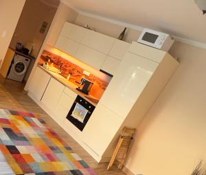 a kitchen with a white refrigerator and a microwave at Gold Sea Apartman in Siófok